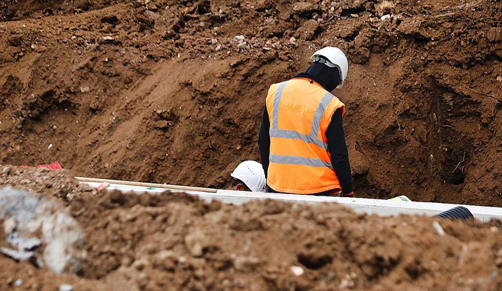 Two workers amongst soil on a building site