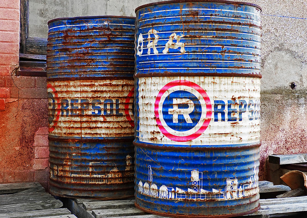 Two aged metal barrels