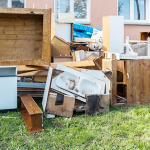Pile of old furniture, cabinetry and household rubbish collected outside a home for professional rubbish removal.