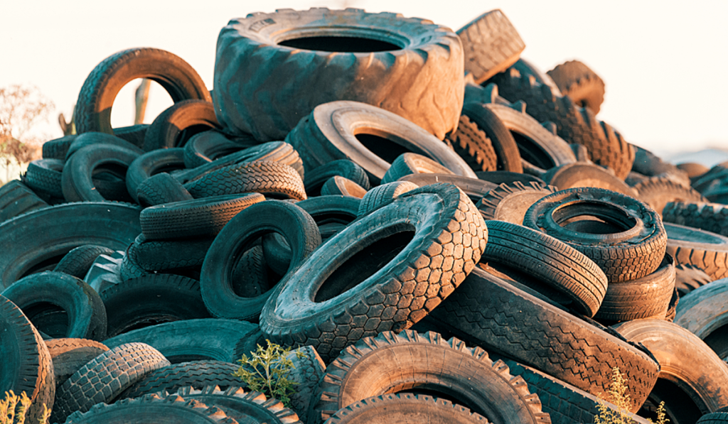Large pile of used tyres awaiting collection and recycling at a tyre disposal facility.