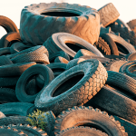 Large pile of used tyres awaiting collection and recycling at a tyre disposal facility.