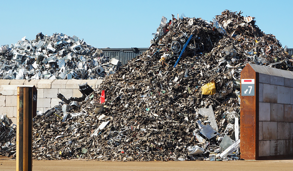 Large piles of scrap metal and recyclable materials at a recycling depot ready for sorting and processing.
