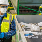 Worker conducting a waste audit at a recycling facility