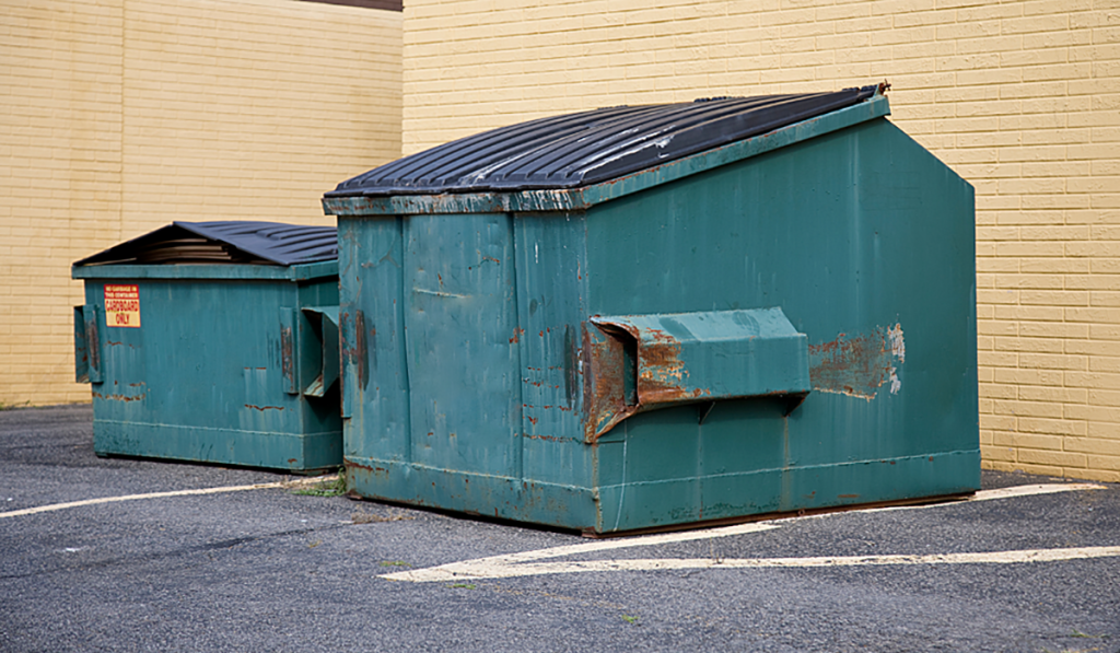 Industrial bin services with large commercial waste bins outside a business premises