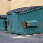 Industrial bin services with large commercial waste bins outside a business premises