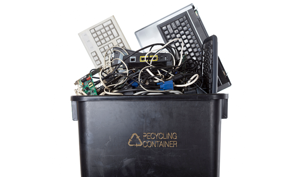 E-waste including computers, keyboards and cables in a recycling container