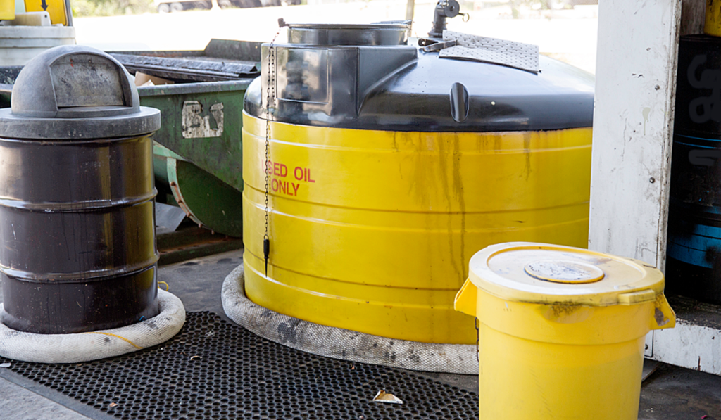 Used oil storage tanks and collection containers at a waste management facility.